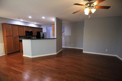 Kitchen featuring dark countertops, dark wood-style floors, stainless steel fridge with ice dispenser, black microwave, and recessed lighting