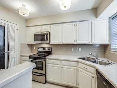 Kitchen with black appliances, light countertops, 