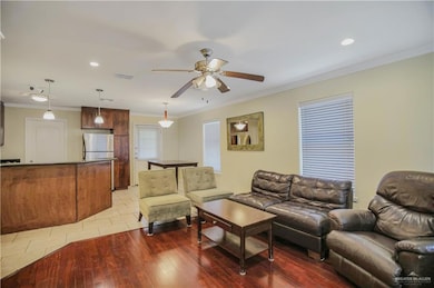 Living area featuring ornamental molding, ceiling fan, wood-type flooring, and recessed lighting