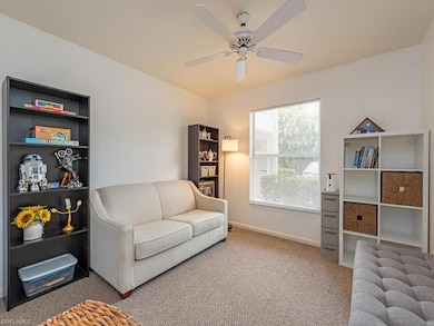 Living area featuring baseboards, ceiling fan, and