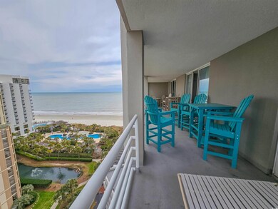 Balcony featuring a view of the beach and a water 