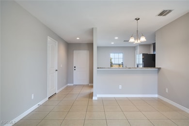 Kitchen featuring fridge, a chandelier, recessed l