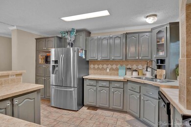 Kitchen featuring crown molding, sink, light tile 