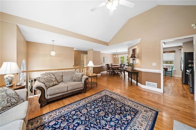 Living room featuring ceiling fan, wood finished floors, and high vaulted ceiling