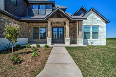 View of exterior entry with a lawn and covered por
