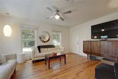 Living room with ceiling fan, healthy amount of n