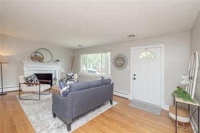 Living area with light wood-type flooring, a firep