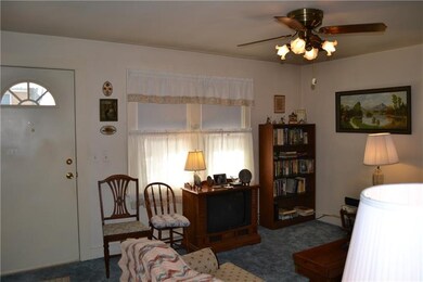 Living room has newer carpet, and ceiling fan.