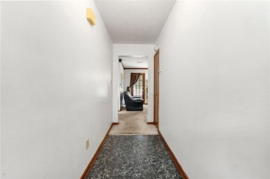 Hall featuring baseboards and a textured ceiling