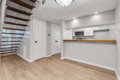 Kitchen featuring a textured ceiling, wooden count