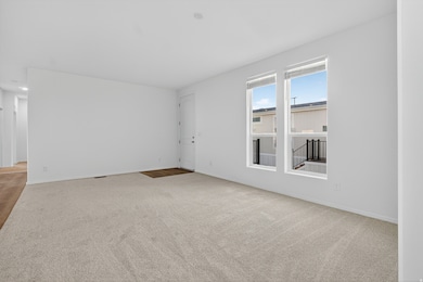 Empty room featuring light colored carpet and baseboards