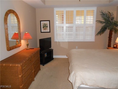 Bedroom with baseboards and light carpet