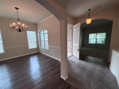 Foyer with arched walkways, a chandelier, ornamen