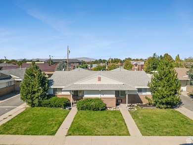 View of front facade featuring a front yard, brick siding, and a shingled roof