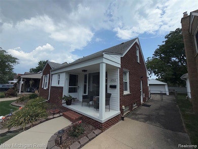 Bungalow-style house featuring a porch, brick siding, and a garage