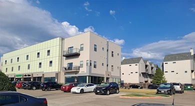 View of building exterior with uncovered parking