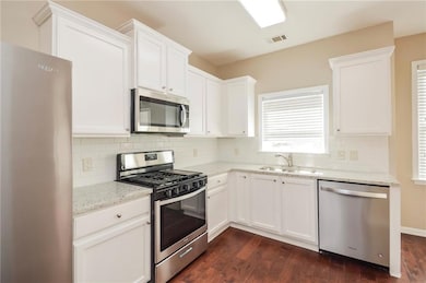 Kitchen with stainless steel appliances, a sink, d
