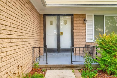 Entrance to property with brick siding, covered porch, and french doors