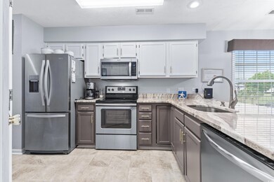 Kitchen with sink, two-toned cabinets, light tile 