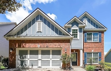 View of front of house featuring brick siding, a garage, and board and batten siding