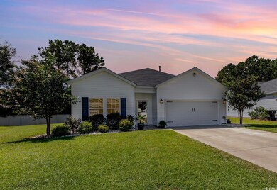 Single story home featuring a garage and a yard