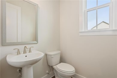 Half bath with toilet and baseboards