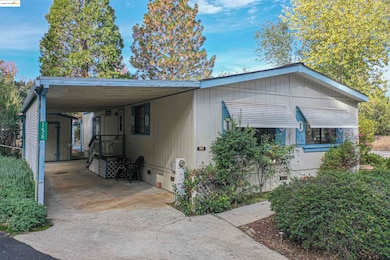 View of home's exterior featuring an attached carport, concrete driveway, and crawl space