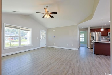 Unfurnished living room featuring light wood finished floors, lofted ceiling, and a ceiling fan