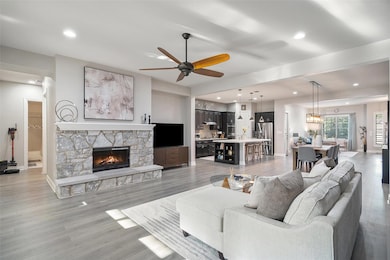 Living room featuring ceiling fan, a fireplace, r