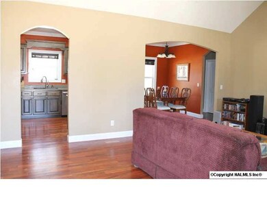 Arched doorways lead from living room into kitchen/dining.