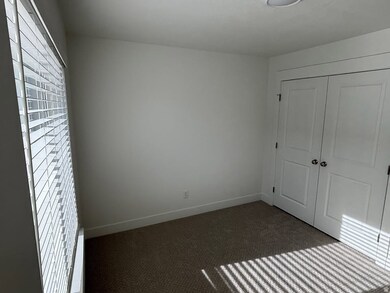 Unfurnished bedroom with dark carpet and a closet
