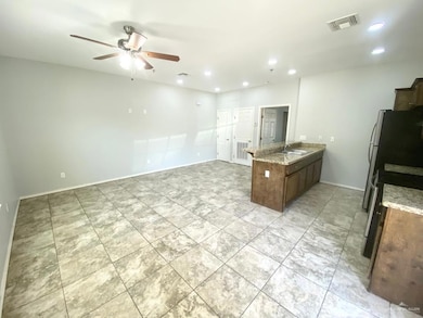 Kitchen featuring visible vents, a sink, a peninsula, stainless steel stove, and ceiling fan
