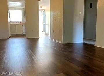Unfurnished room with dark wood-type flooring