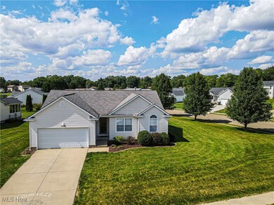 Ranch-style home with a front lawn and a garage