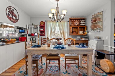 Dining room with light wood-type flooring, a chandelier, and a textured ceiling