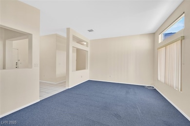 Carpeted spare room with baseboards and built in features