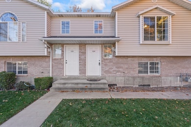 Entrance to property featuring brick siding and a yard