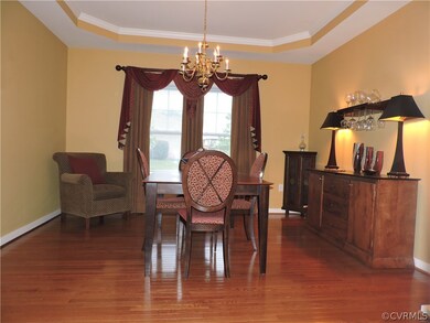 Formal dining room with tray ceiling and wood floo