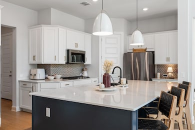 Pendant lighting adds just the right touch of drama, making the kitchen island an irresistible gathering spot for meals, homework, or happy hour.