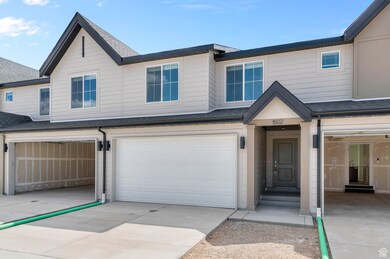 View of front facade featuring a shingled roof, concrete driveway, and a garage