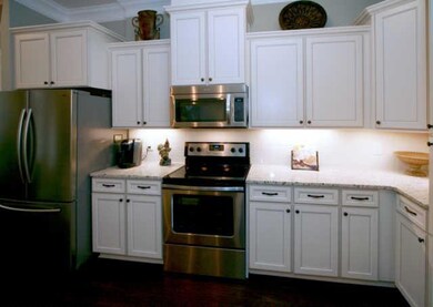 The kitchen is nice and bright with light cabinets, tile backsplash and granite counters, stainless steel appliances and undercabinet lighting. Bar seating also adds for more seating for friends and family.