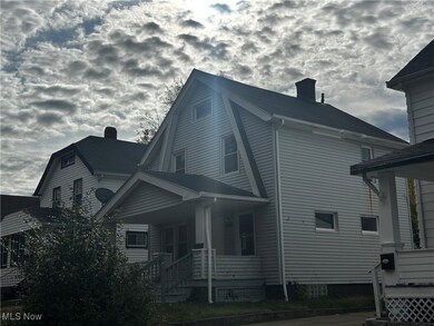 View of home's exterior featuring a chimney, a porch, and a gambrel roof