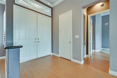 Foyer entrance with baseboards, light wood-style f