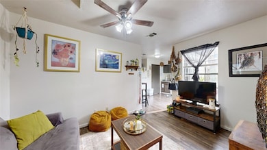 Living area with baseboards, dark wood-type floori