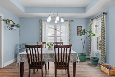 Dining space featuring baseboards, a tray ceiling,