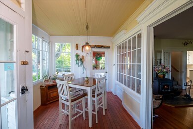 Breakfast nook in the enclosed porch offers wall o