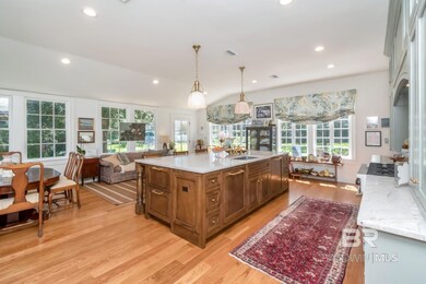 Kitchen with hanging light fixtures, light stone countertops, open floor plan, light wood-type flooring, and recessed lighting