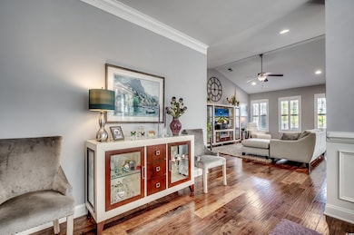 Interior space with hardwood / wood-style flooring, ceiling fan, ornamental molding, and vaulted ceiling