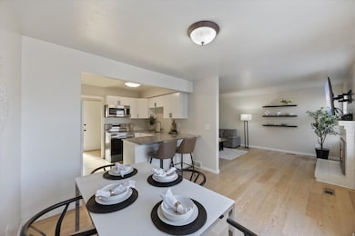 Dining room with light wood-type flooring and a fireplace