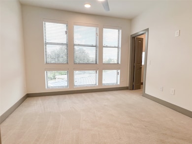 Unfurnished room with plenty of natural light, light carpet, ceiling fan, and recessed lighting